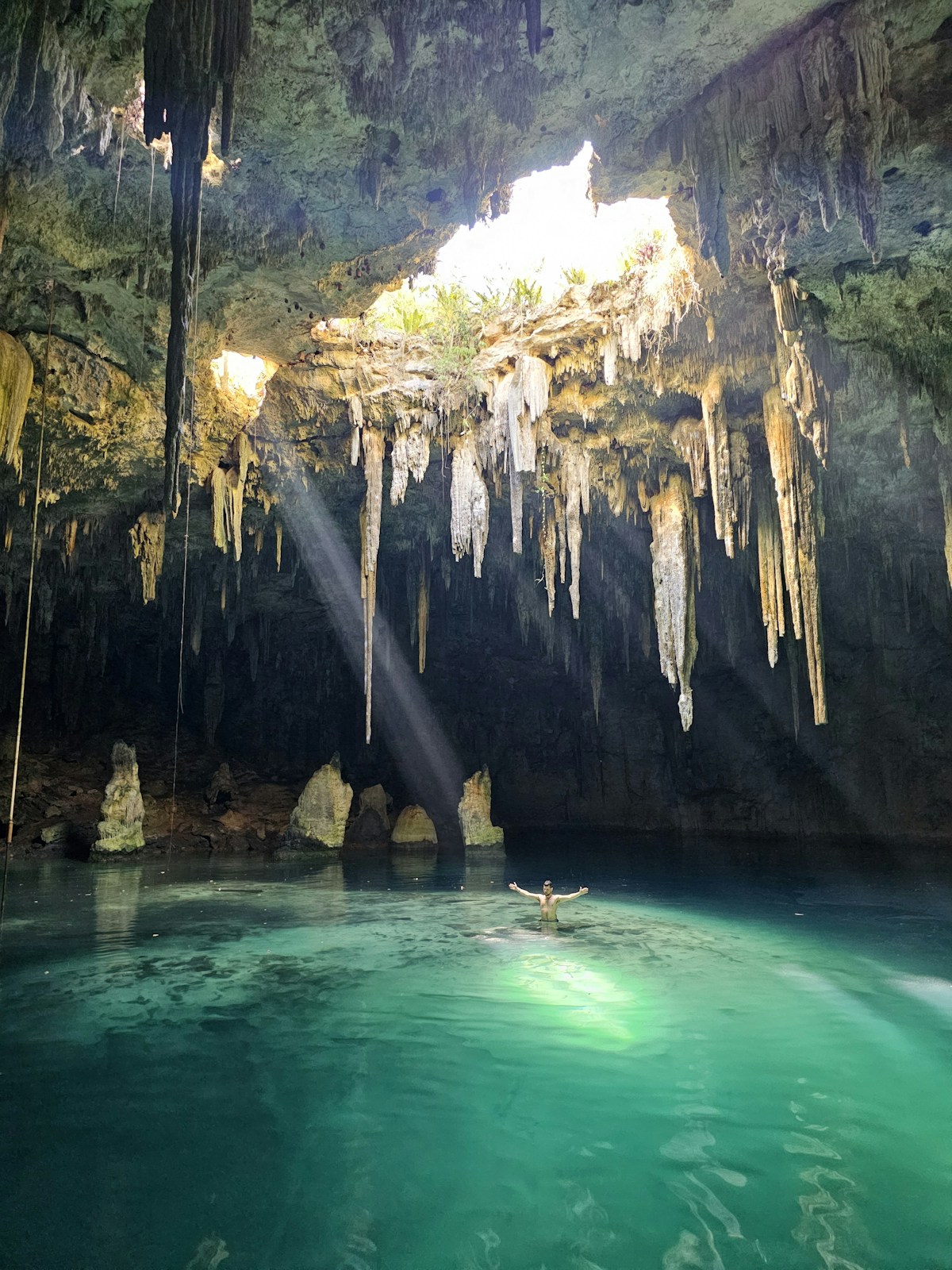 Cenote cave pool with crystal-clear water and stalactites