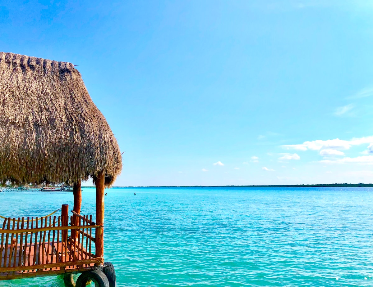Bacalar lagoon with turquoise water and a thatch hut on the shore